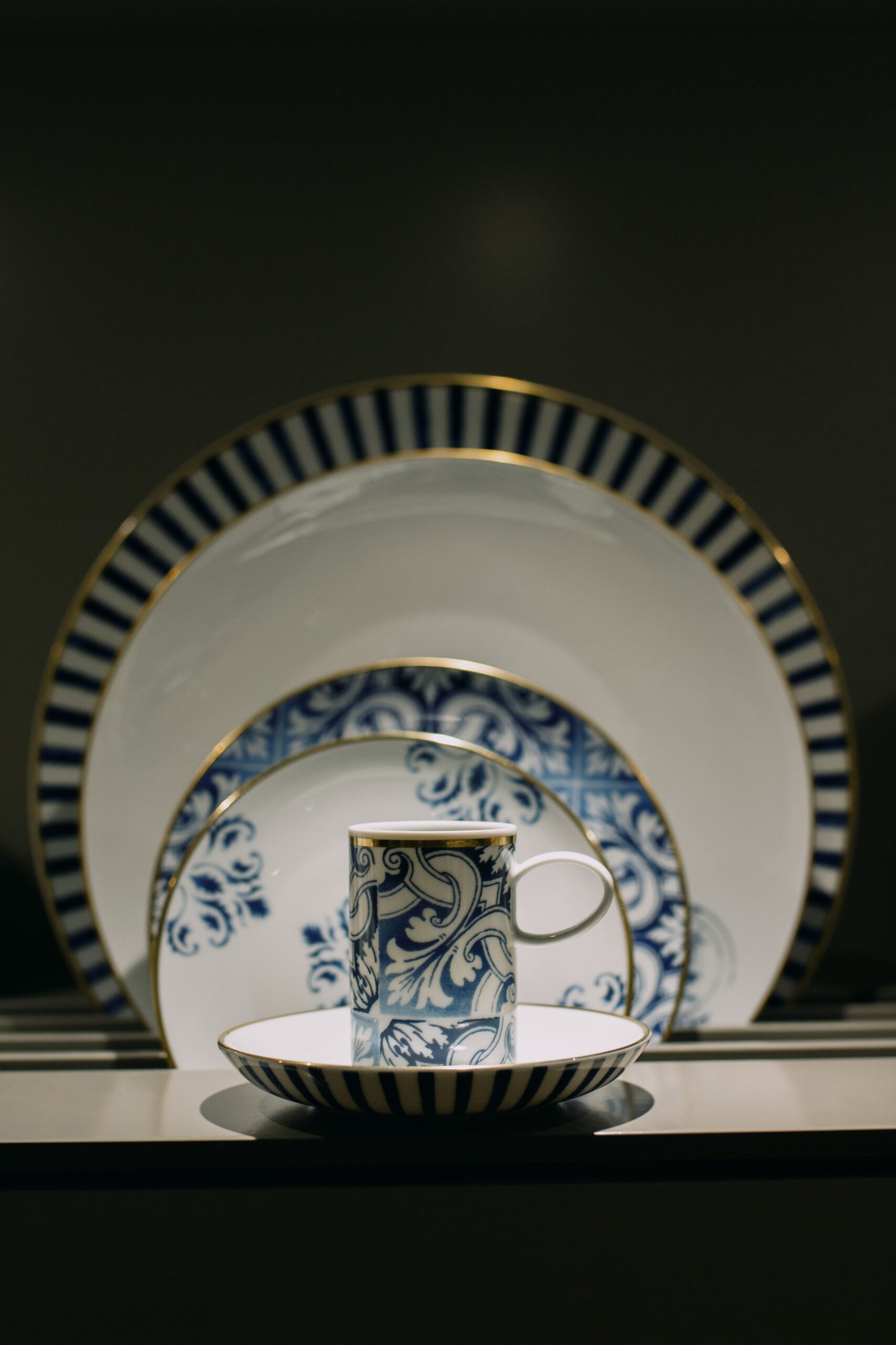 Blue and white ceramic cup with matching plates featuring a classic decorative pattern